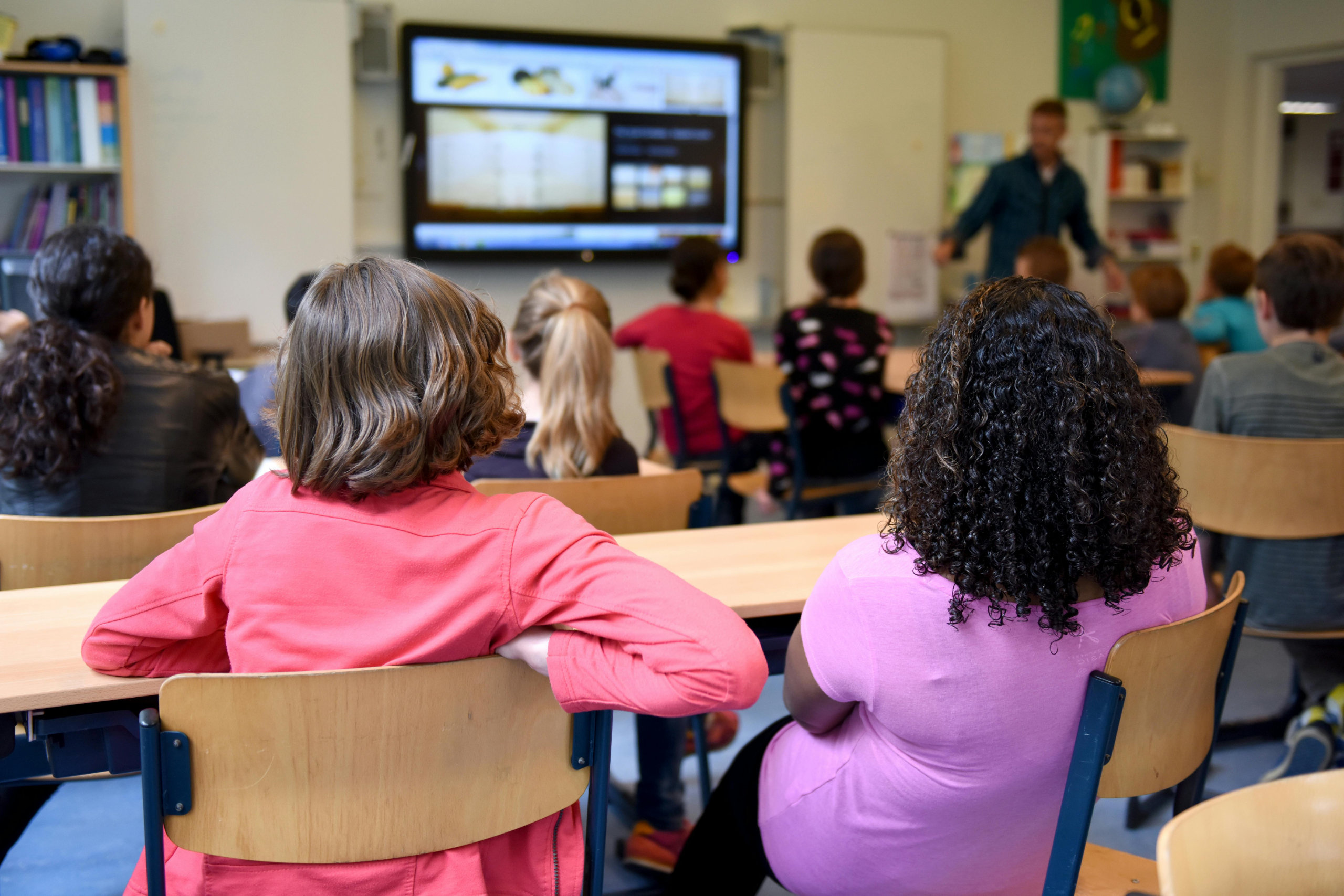Klassenzimmer mit Kindern beim Unterricht mit Blick nach vorne 
